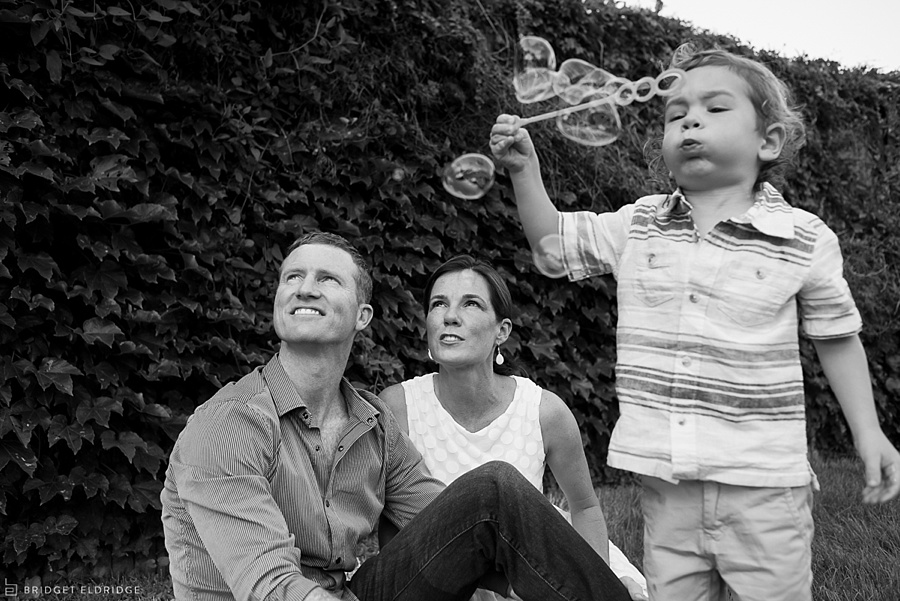 parents look on as child blows bubbles