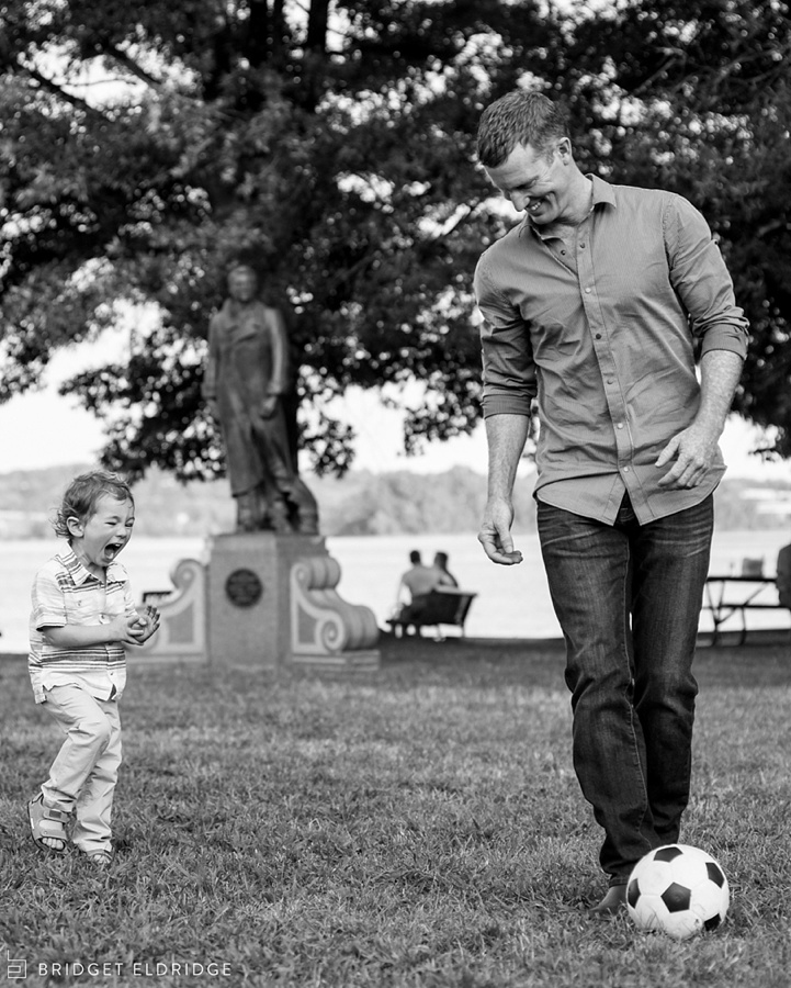 boys plays soccer with his dad